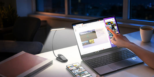 Rechargeable flexible LED gooseneck light clipped to a desk, illuminating a laptop keyboard for late-night work.
